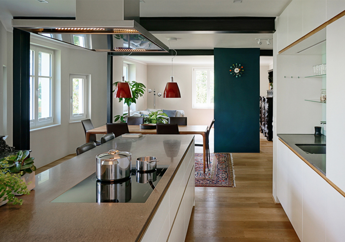 Der neue Küchenbereich ist optisch mit einem farbigen Raumteiler vom Wohnbereich abgetrennt 