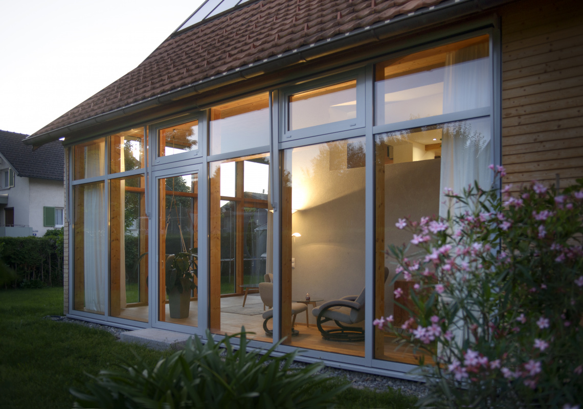 Blick von aussen ins Wohnzimmer im Abendlicht