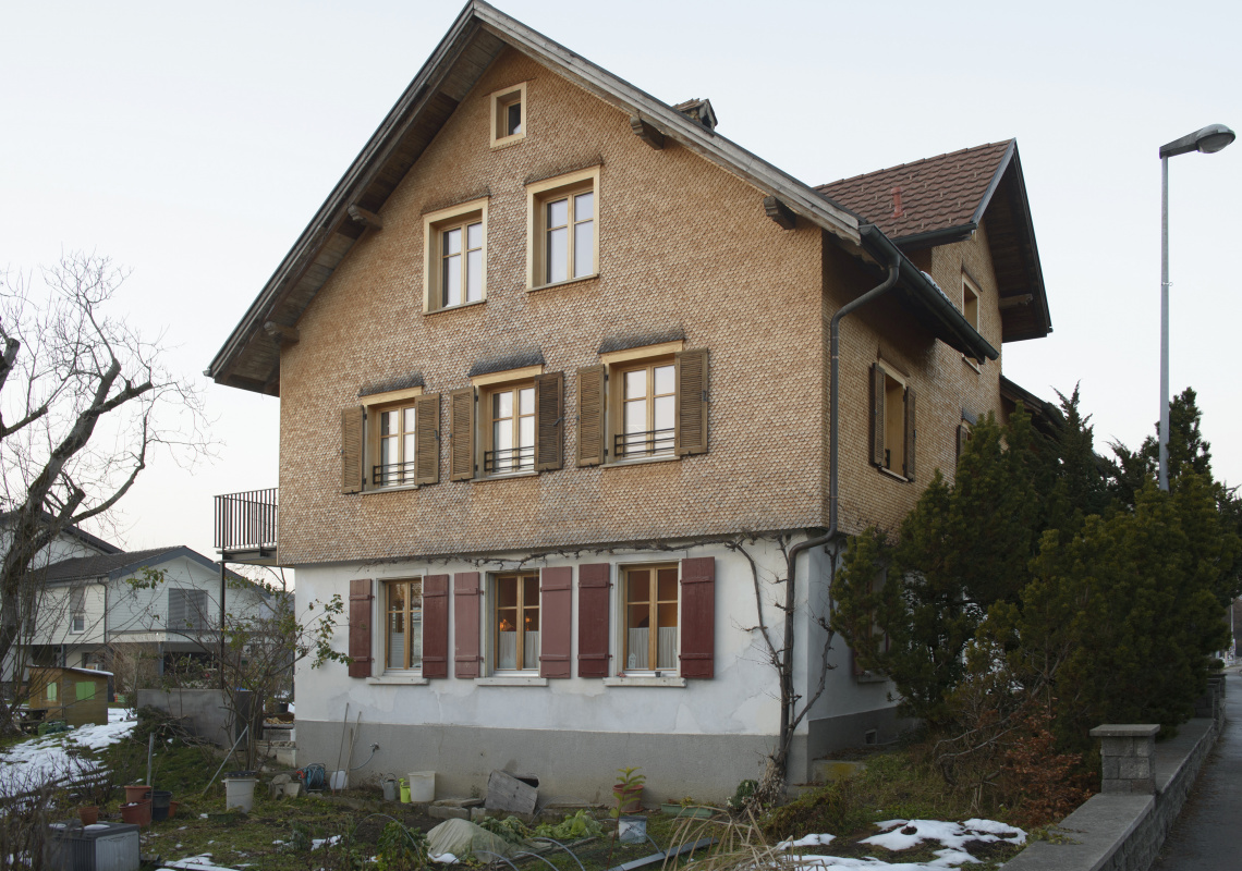 Holzschindelfassade im Obergeschoss, aufwendig ausgeführte Fensterläden