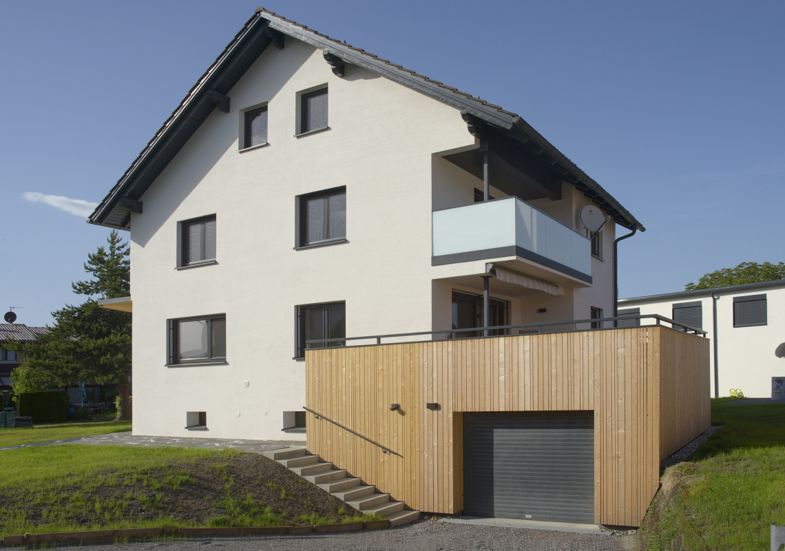 Ansicht nach der Sanierung mit Garage, Terrasse aus Holz