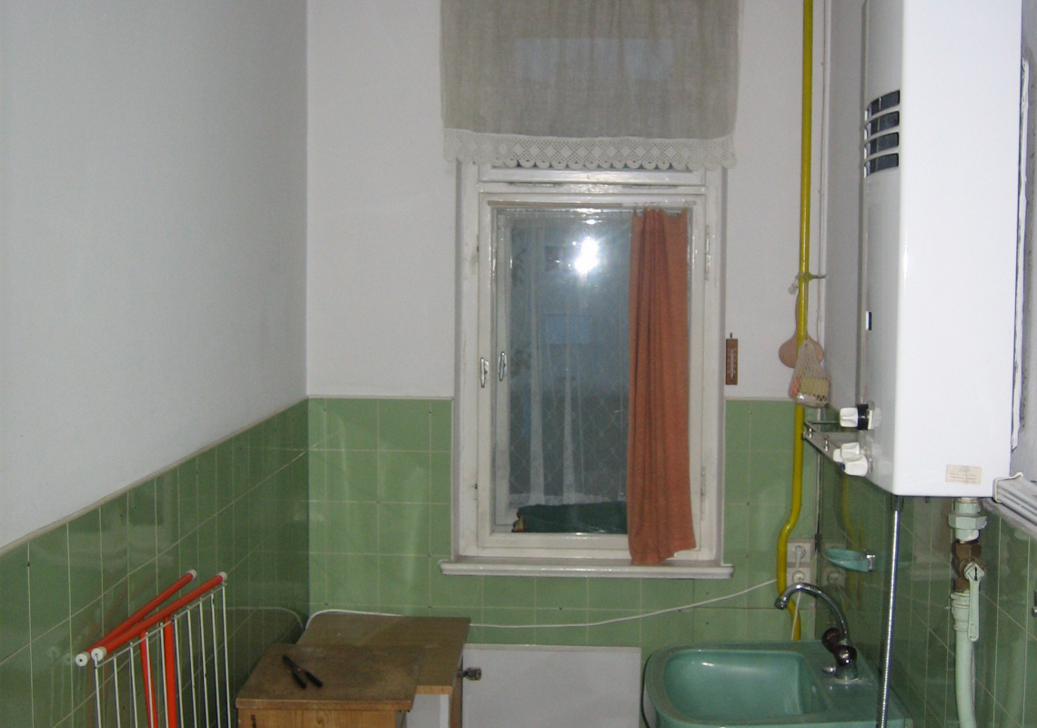 Das Bad vorher mit Elektroboiler, unverbauten Leitungen und altem Fenster