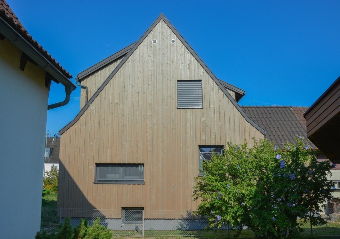 © Andrea Vogel-Sonderegger Neue einheitliche Fassade aus lasierter Fichtenholz-Boden-Deckelschalung