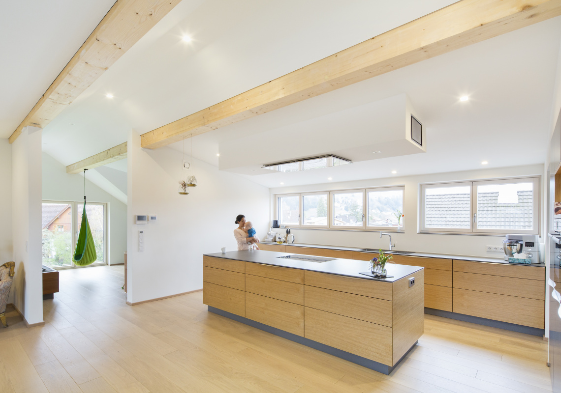 Moderner und großzügiger Küchenbereich  mit alten Balken an der Decke 