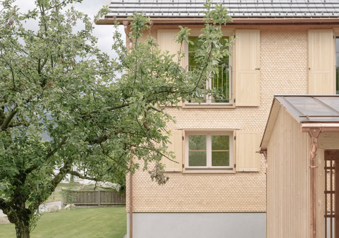 Schindelfassade und Carport aus Holz im Vordergrund